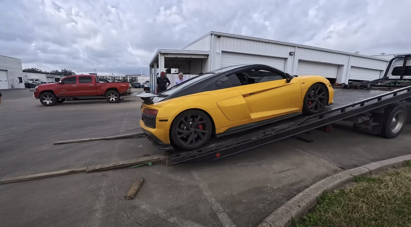Luxury vehicle being loaded onto flatbed tow truck for safe transport